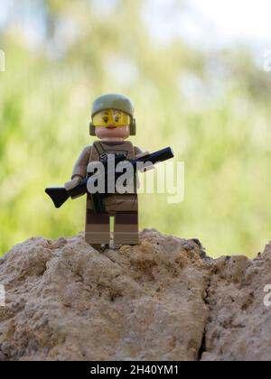 Tschernihiw, Ukraine, 13. Juli 2021. Ein Mädchen, das mit einem Gewehr bewaffnet ist. Ein kleines Plastikspielzeug. Illustratives Editorial. Stockfoto