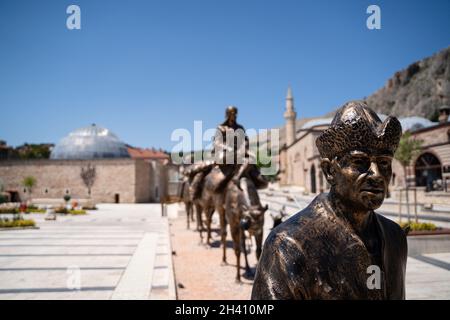 TOKAT, TÜRKEI - 6. AUGUST 2021: Gruppe von Bronzestatuen, die eine Karawane mit Männern und Kamelen vor dem historischen Museum von Tokat darstellen Stockfoto