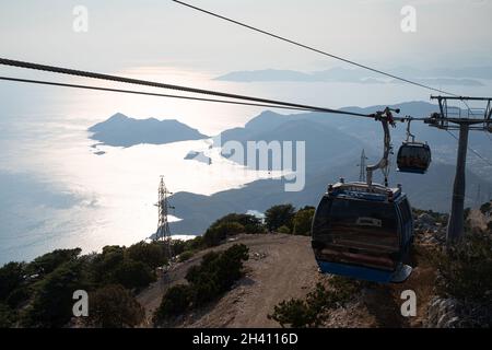 OLUDENIZ, TÜRKEI - 25. JULI 2021: Teleferik-Seilbahnen von Oludeniz zum Babadag-Gipfel mit Blick auf hohe Berge, die über dem Mittelmeer emporragen Stockfoto