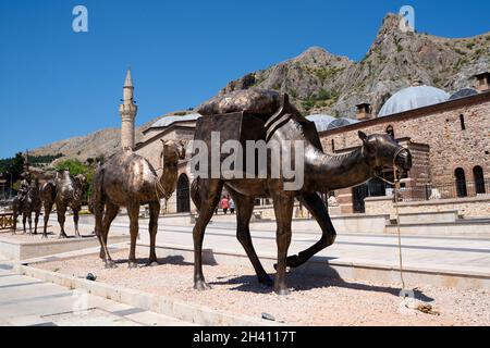 TOKAT, TÜRKEI - 6. AUGUST 2021: Gruppe von Bronzestatuen, die eine Karawane mit Männern und Kamelen vor dem historischen Museum von Tokat darstellen Stockfoto