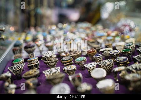 ISTANBUL, TÜRKEI - 17. JULI 2021: Perspektivische Ansicht von Reihen silberner Ringe mit farbigen Steinen im Schaufenster des Großen Basars Stockfoto