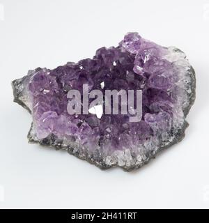 Natürliches violettes Amethyst-Druse-Cluster auf weißem Hintergrund Stockfoto