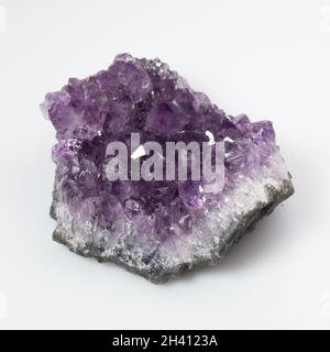 Natürliches violettes Amethyst-Druse-Cluster auf weißem Hintergrund Stockfoto