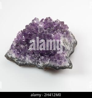 Natürliches violettes Amethyst-Druse-Cluster auf weißem Hintergrund Stockfoto