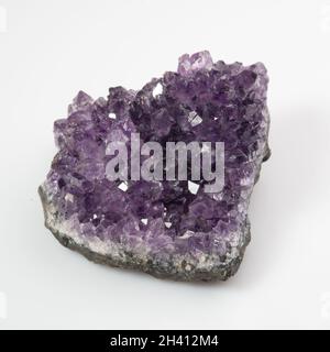 Natürliches violettes Amethyst-Druse-Cluster auf weißem Hintergrund Stockfoto