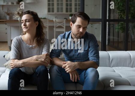 Deprimiert unglückliches junges Paar, das auf dem Sofa sitzt. Stockfoto