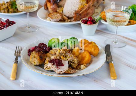 Traditionelles Weihnachtsessen mit gebratenem truthahn, Aprikosen- und Pistazien-Füllung, Bratkartoffeln und Cranberry-Sauce Stockfoto