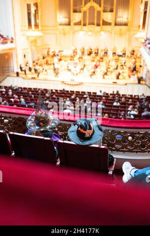 Hamburg, Deutschland. Oktober 2021. Zahlreiche Kinder, teilweise verkleidet, hören das Konzert des Hamburger Symphonieorchesters im großen Saal der Laeiszhalle. Für das Halloween-Konzert zum Auftakt der Kinderkonzertsaison wurden junge und alte Gäste eingeladen, sich zu verkleiden. Es war das erste Kinderkonzert nach einer langen Pause aufgrund der Corona-Pandemie. Quelle: Jonas Walzberg/dpa/Alamy Live News Stockfoto