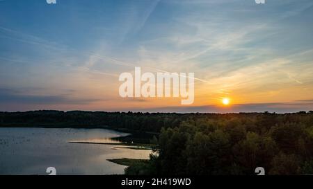 Luftaufnahme einer ländlichen Landschaft bei Sonnenaufgang in Belgien. Ländliche Farm, Maisfelder, grüne Felder, Sonnenlicht und Nebel. Belgien, Eu Stockfoto