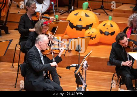 Hamburg, Deutschland. Oktober 2021. Im großen Saal der Laeiszhalle spielen Musiker des Hamburger Symphonieorchesters zwischen Kürbisdekorationen. Für das Halloween-Konzert zum Auftakt der Kinderkonzertsaison wurden junge und alte Gäste eingeladen, sich in die Laeiszhalle zu kleiden. Es war das erste Kinderkonzert nach einer langen Pause. Quelle: Jonas Walzberg/dpa/Alamy Live News Stockfoto