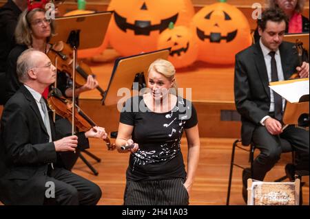 Hamburg, Deutschland. Oktober 2021. Moderatorin Singa Gätgens steht vor dem Hamburger Symphonieorchester im großen Saal der Laeiszhalle auf der Bühne. Für das Halloween-Konzert zum Auftakt der Kinderkonzertsaison wurden junge und alte Gäste eingeladen, sich in die Laeiszhalle zu kleiden. Es war das erste Kinderkonzert nach einer langen Pause. Quelle: Jonas Walzberg/dpa/Alamy Live News Stockfoto