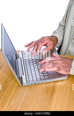 Vertikales Porträt eines älteren Herrn, der auf seinem Laptop vor weißem Hintergrund im Internet surft. Stockfoto