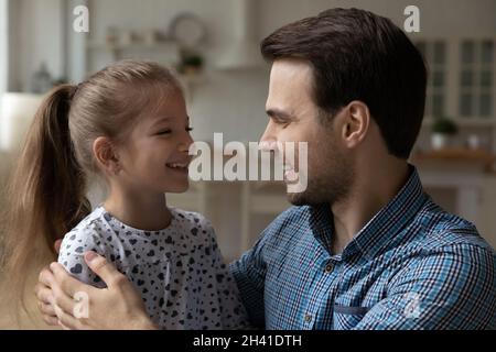 Glückliches kleines Mädchen im Gespräch mit fröhlichem Vater. Stockfoto