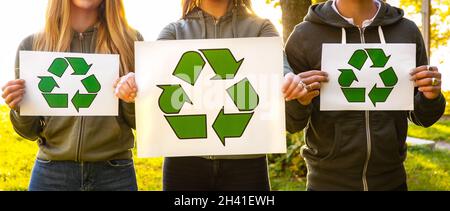 Weite Ansicht des Teams von Freiwilligen aus dem Umweltschutz, die Schilder mit Recycling-Symbolen halten Stockfoto