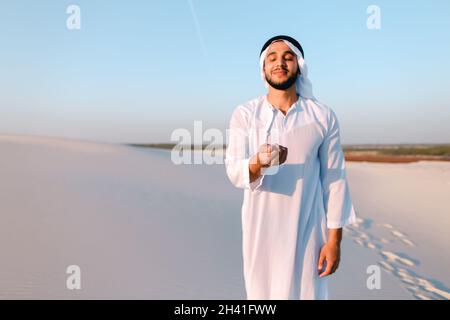 Portrait eines muslimischen Mannes in der sandigen Wüste an einem klaren Sommernachmittag im Freien. Stockfoto