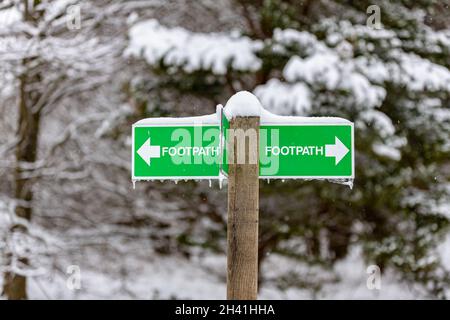 Öffentliches Wanderwegschild mit schneebedeckten Eiszapfen auf dem Boden der britischen Landschaft Stockfoto