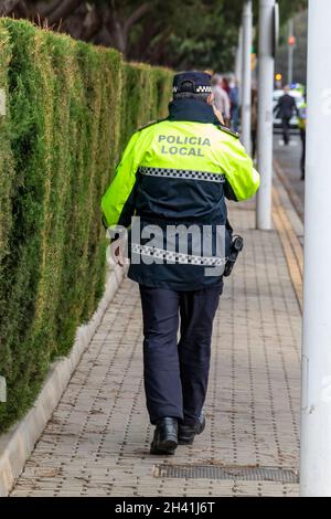 Huelva, Spanien - 30. Oktober 2021: Rückansicht der spanischen Polizei mit dem Logo der lokalen Polizei auf Uniform Aufrechterhaltung der öffentlichen Ordnung in den Straßen von Hue Stockfoto