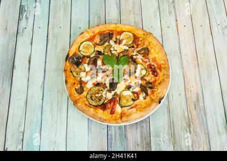 Hortelana Gemüsepizza mit Zucchini-, Aubergine-, Paprika- und Pilzscheiben mit Basilikum und Mozzarella-Käse Stockfoto