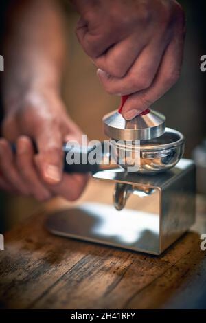 Nahaufnahme der Hände eines Barkeepers, die einen aromatischen und duftenden Espresso zubereiten. Kaffee, Getränke, Bar Stockfoto