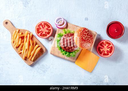 Burger-Zutaten, darüber liegende flache Lay Shot. Hamburger Patty Steak, Pommes frites Stockfoto