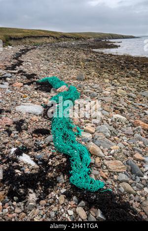 Ausrangierte Fischernetzes wurden am Ufer von Basta Voe vor der Insel Yell, Shetland, gespült Stockfoto