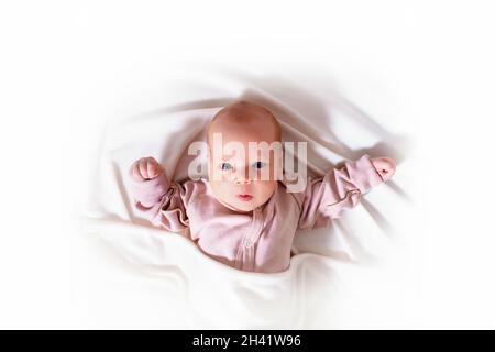 Neugeborenes Mädchen auf einer weißen, isolierten Decke. Stockfoto