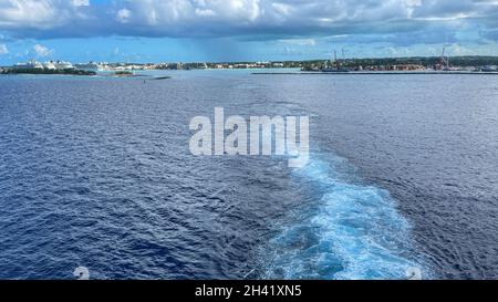 Ein Kreuzschiff wacht an einem wunderschönen stürmischen Tag auf, mit dunklen Wolken und blauen Meeren auf dem Atlantischen Ozean, der von Nassau, Bahamas, abfährt. Stockfoto