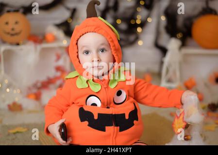 Kind als Kürbis für Halloween gekleidet Stockfoto