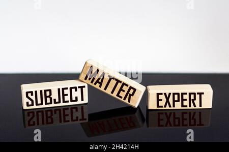 TEXTGEGENSTAND EXPERTE für Holzblöcke und schwarz-weißen Hintergrund. Stockfoto