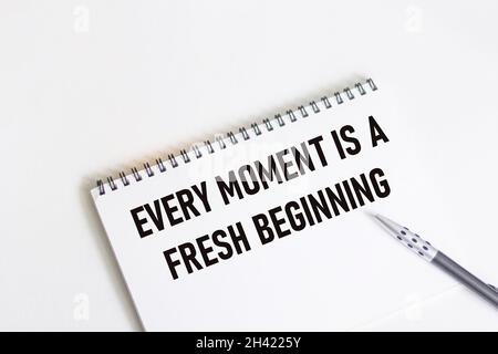 Jeder Moment ist ein neuer Anfang. Inspirierendes Zitat auf Notizblock mit Stift. Stockfoto