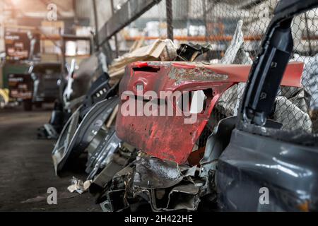Haufen alter rostiger, zerlegter Autoteile in der Halle für die Abfalllagerung in der Werkstatt. Fahrzeugbergung Demontage Garage. Iron Auto Spare Details Trunk Stockfoto