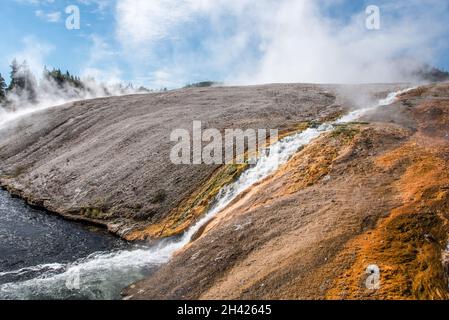 Ein kleiner Strom von heißem Wasser fließt in einem natürlichen Pool, Yellowstone NP, USA Stockfoto