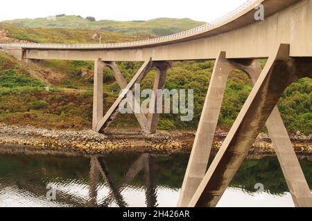 Ein Blick auf die Kylesku-Brücke, Sutherland, Schottland, mit ihrer geschwungenen Form und riesigen Stützen über dem Loch A Chairn Bhain Stockfoto