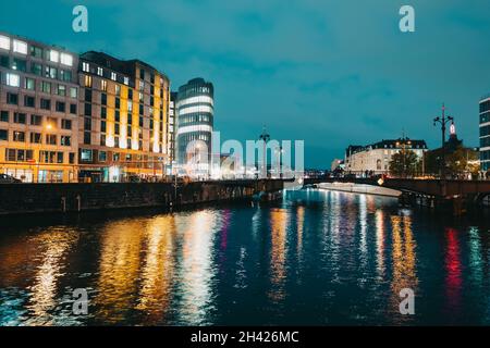 Oktober 2021 - Berlin, Deutschland. Nachtansicht der historischen belebten Straße, Brücke unter der Spree. Langzeitbelichtung, Verkehr auf der Friedrichstraße in Germanisch Stockfoto