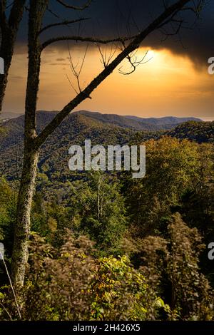 Eine vertikale Aufnahme einer großartigen Aussicht von der Spitze einer Klippe, Bäume und Berge, Sonnenlicht Stockfoto