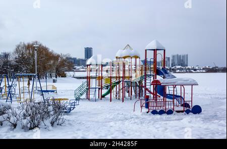 Kinderspielplatz im Schnee auf dem See im Stadtpark Stockfoto