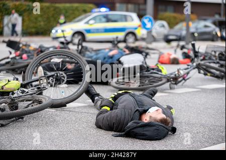 Hamburg, Deutschland. Oktober 2021. Dutzende von Menschen beteiligten sich an einem „Eintreffen“ für den Radfahrer, der am vergangenen Freitag tödlich verletzt wurde, als er von einem Lastwagen überfahren wurde und sich fünf Minuten lang an der Unfallkreuzung auf ihre Räder legte. Quelle: Jonas Walzberg/dpa/Alamy Live News Stockfoto