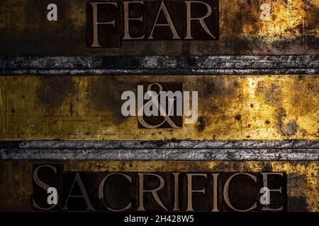 Furcht und Opfer Text auf texturiertem Grunge Kupfer und Vintage Gold Hintergrund Stockfoto