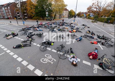 Hamburg, Deutschland. Oktober 2021. Dutzende von Menschen beteiligten sich an einem „Eintreffen“ für den Radfahrer, der am vergangenen Freitag tödlich verletzt wurde, als er von einem Lastwagen überfahren wurde und sich fünf Minuten lang an der Unfallkreuzung auf ihre Räder legte. Quelle: Jonas Walzberg/dpa/Alamy Live News Stockfoto