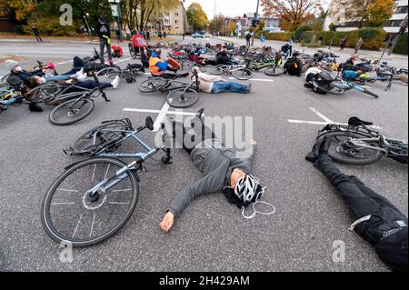 Hamburg, Deutschland. Oktober 2021. Dutzende von Menschen beteiligten sich an einem „Eintreffen“ für den Radfahrer, der am vergangenen Freitag tödlich verletzt wurde, als er von einem Lastwagen überfahren wurde und sich fünf Minuten lang an der Unfallkreuzung auf ihre Räder legte. Quelle: Jonas Walzberg/dpa/Alamy Live News Stockfoto