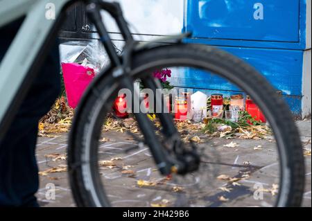 Hamburg, Deutschland. Oktober 2021. Am Unfallort wird neben Trauerkerzen und Blumen ein Fahrrad vorbeigefahren. Dutzende von Menschen beteiligten sich an einem „Eintreffen“ für den Radfahrer, der am vergangenen Freitag tödlich verletzt wurde, als er von einem Lastwagen überfahren wurde und sich fünf Minuten lang an der Unfallkreuzung auf ihre Fahrräder legte. Quelle: Jonas Walzberg/dpa/Alamy Live News Stockfoto