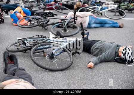 Hamburg, Deutschland. Oktober 2021. Dutzende von Menschen beteiligten sich an einem „Eintreffen“ für den Radfahrer, der am vergangenen Freitag tödlich verletzt wurde, als er von einem Lastwagen überfahren wurde und sich fünf Minuten lang an der Unfallkreuzung auf ihre Räder legte. Quelle: Jonas Walzberg/dpa/Alamy Live News Stockfoto