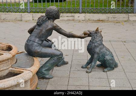 Budapest, Ungarn - 22. Oktober 2021: Bronzestatue auf der Straße eines Mädchens mit ihrem Hund in Budapest, Ungarn. Stockfoto