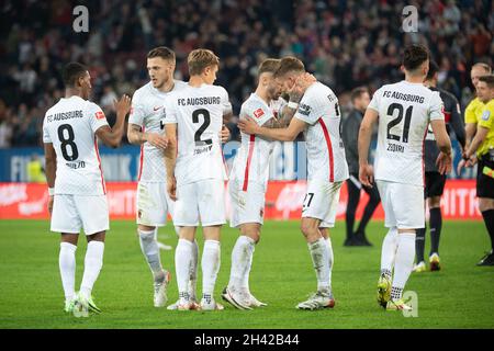 Augsburg, Deutschland. Oktober 2021. Fußball: Bundesliga, FC Augsburg - VfB Stuttgart, Matchday 10, WWK Arena. Augsburger Spieler feiern ihren Sieg. Quelle: Matthias Balk/dpa - WICHTIGER HINWEIS: Gemäß den Bestimmungen der DFL Deutsche Fußball Liga und/oder des DFB Deutscher Fußball-Bund ist es untersagt, im Stadion und/oder vom Spiel aufgenommene Fotos in Form von Sequenzbildern und/oder videoähnlichen Fotoserien zu verwenden oder zu verwenden./dpa/Alamy Live News Stockfoto