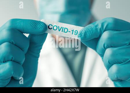 Medizinischer Facharzt weiß Pflaster mit Covid-19-Etikett für Patienten nach der Impfung, selektiver Fokus Stockfoto