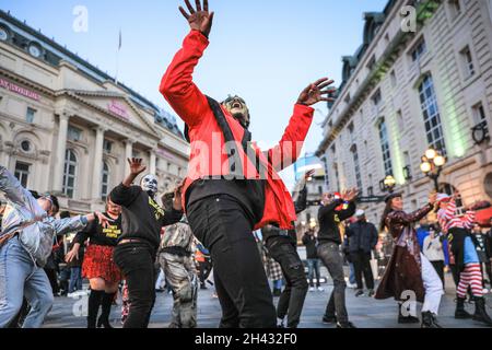 Piccadilly Circus, London, Großbritannien. Oktober 2021. Die Tänzer erstellen die berühmten Zombie-Tanzszenen aus Michael Jacksons „Thriller“-Video neu. Feiernden nehmen an einem Halloween-Tanz-Flashmob Teil, darunter eine Gruppe von Locals.org, einer sozialen Plattform mit Sitz in London, und treffen sich, um Londoners zusammenzubringen. Passanten werden ermutigt, mitzumachen und zu tanzen. Kredit: Imageplotter/Alamy Live Nachrichten Stockfoto