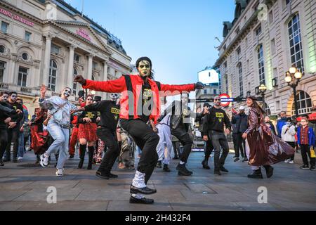 Piccadilly Circus, London, Großbritannien. Oktober 2021. Die Tänzer erstellen die berühmten Zombie-Tanzszenen aus Michael Jacksons „Thriller“-Video neu. Feiernden nehmen an einem Halloween-Tanz-Flashmob Teil, darunter eine Gruppe von Locals.org, einer sozialen Plattform mit Sitz in London, und treffen sich, um Londoners zusammenzubringen. Passanten werden ermutigt, mitzumachen und zu tanzen. Kredit: Imageplotter/Alamy Live Nachrichten Stockfoto