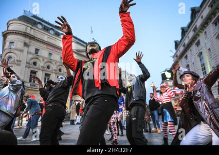 Piccadilly Circus, London, Großbritannien. Oktober 2021. Die Tänzer erstellen die berühmten Zombie-Tanzszenen aus Michael Jacksons „Thriller“-Video neu. Feiernden nehmen an einem Halloween-Tanz-Flashmob Teil, darunter eine Gruppe von Locals.org, einer sozialen Plattform mit Sitz in London, und treffen sich, um Londoners zusammenzubringen. Passanten werden ermutigt, mitzumachen und zu tanzen. Kredit: Imageplotter/Alamy Live Nachrichten Stockfoto