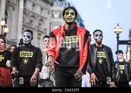 Piccadilly Circus, London, Großbritannien. Oktober 2021. Die Tänzer erstellen die berühmten Zombie-Tanzszenen aus Michael Jacksons „Thriller“-Video neu. Feiernden nehmen an einem Halloween-Tanz-Flashmob Teil, darunter eine Gruppe von Locals.org, einer sozialen Plattform mit Sitz in London, und treffen sich, um Londoners zusammenzubringen. Passanten werden ermutigt, mitzumachen und zu tanzen. Kredit: Imageplotter/Alamy Live Nachrichten Stockfoto