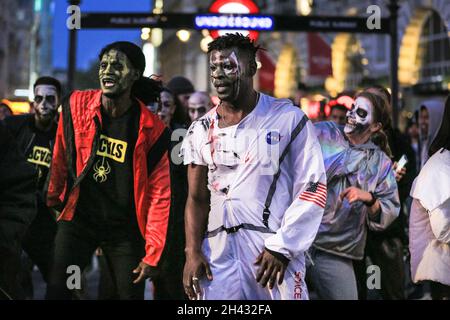 Piccadilly Circus, London, Großbritannien. Oktober 2021. Die Tänzer erstellen die berühmten Zombie-Tanzszenen aus Michael Jacksons „Thriller“-Video neu. Feiernden nehmen an einem Halloween-Tanz-Flashmob Teil, darunter eine Gruppe von Locals.org, einer sozialen Plattform mit Sitz in London, und treffen sich, um Londoners zusammenzubringen. Passanten werden ermutigt, mitzumachen und zu tanzen. Kredit: Imageplotter/Alamy Live Nachrichten Stockfoto